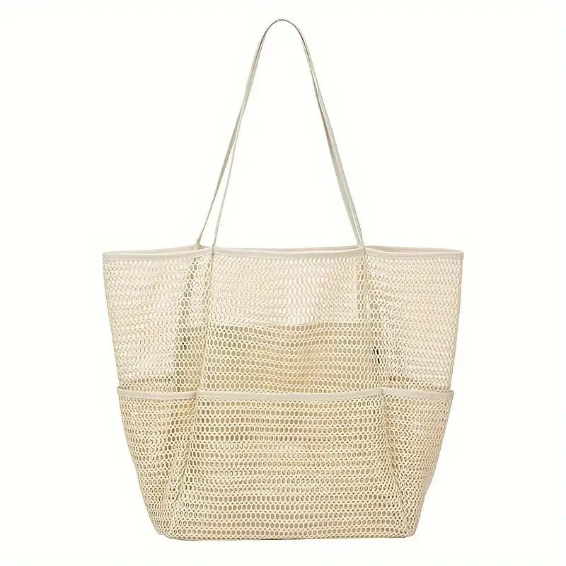 Versatile multi-pocket mesh beach bag in black, shown holding various beach essentials, for outdoor use