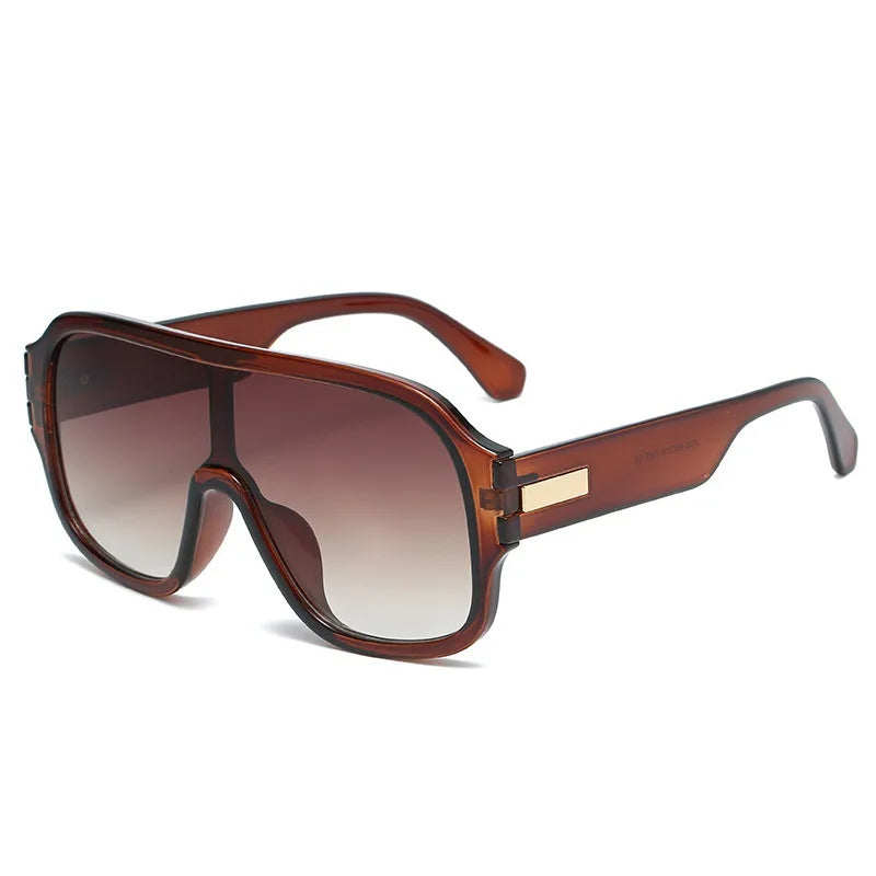 Stylish unisex eyewear: oversized sunglasses with unique gradient lenses and subtle metal frame details.