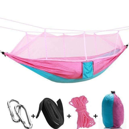 Folding camping hammock with a protective mosquito net, perfect for serene outdoor relaxation.