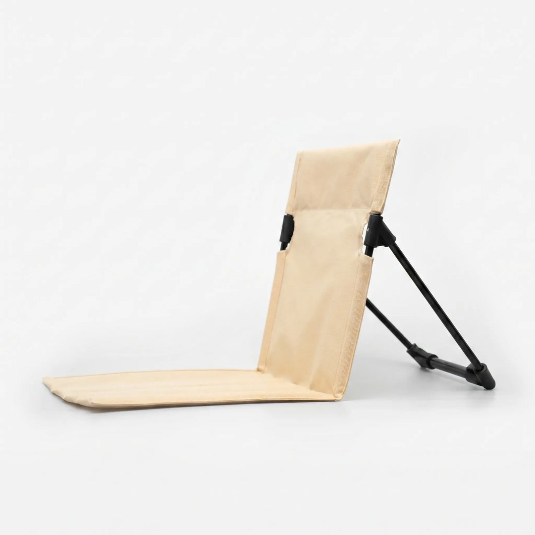 Lightweight folding ground chair with back support for comfortable outdoor seating on grass or sand.