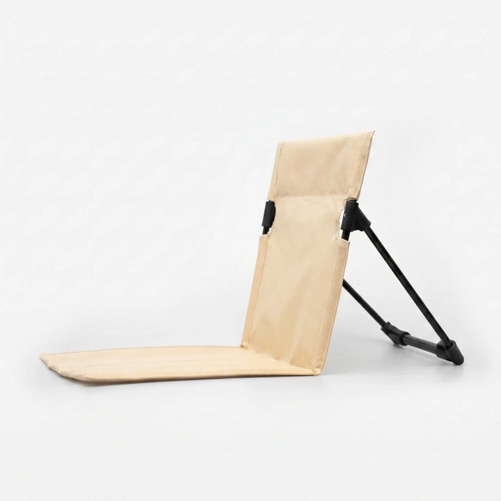 Lightweight folding ground chair with back support for comfortable outdoor seating on grass or sand.