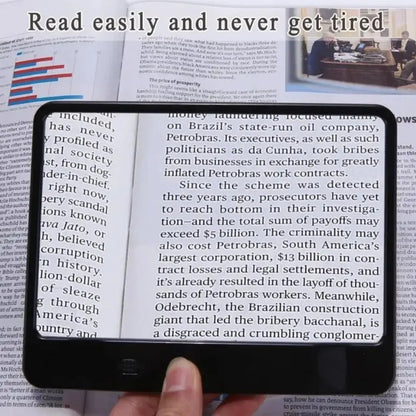 Bright LED light illuminates text under a portable reading magnifier, ideal for low vision.