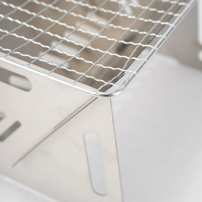 Folded stainless steel camping grill, perfect for portable outdoor cooking and survival gear.