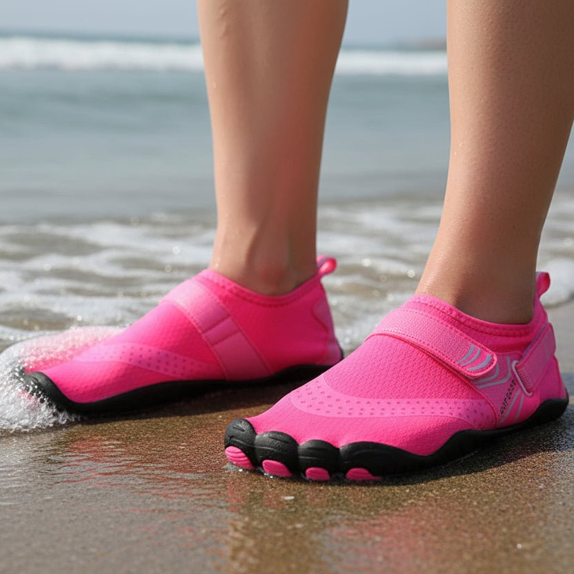 Person wearing unisex quick-dry water shoes on sandy beach. Perfect for swimming, boating, and vacation.