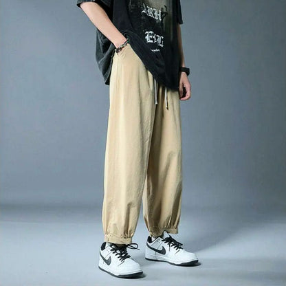 Relaxed fit drawstring athleisure pants featuring an elastic cuff for unisex comfort & style.