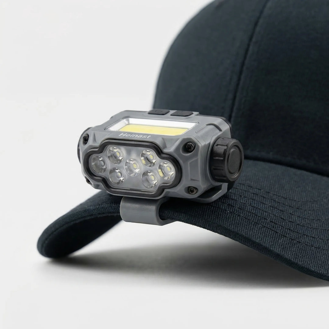 USB rechargeable LED clip light attaches to hats for hands-free illumination during camping, fishing, and hiking.
