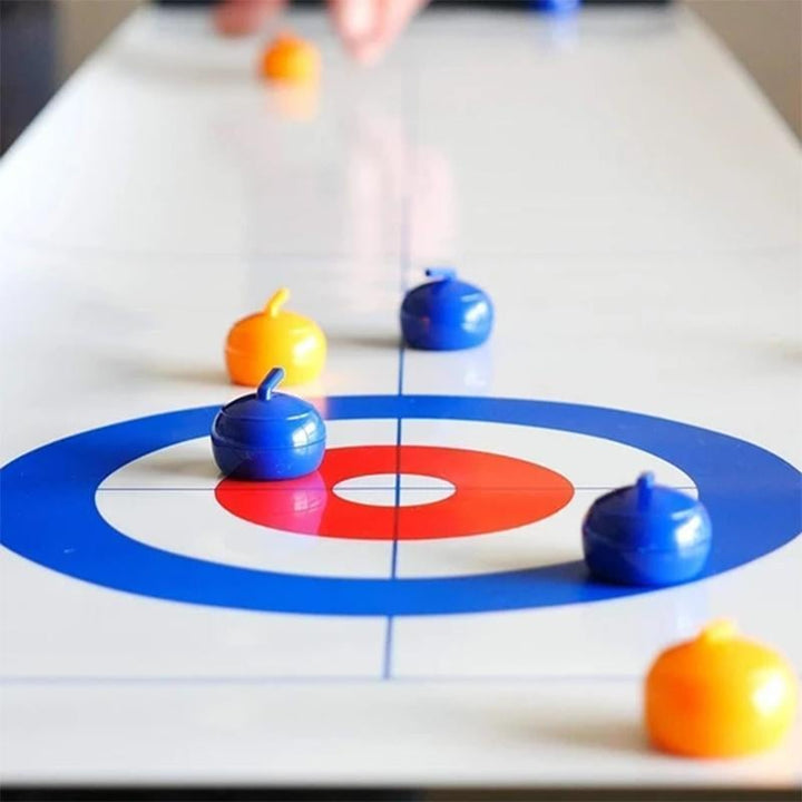 Close-up of a red curling stone gliding across the Tabletop Curling game surface.