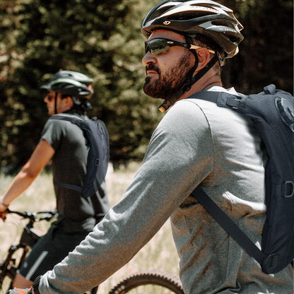 Side view of black 3L tactical hydration pack, showing molle webbing and shoulder straps for hiking