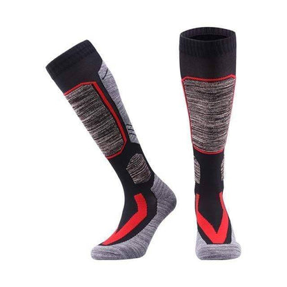 Model wearing black unisex thermal fleece winter socks, paired with ski boots, illustrating their use for cold weather sports.