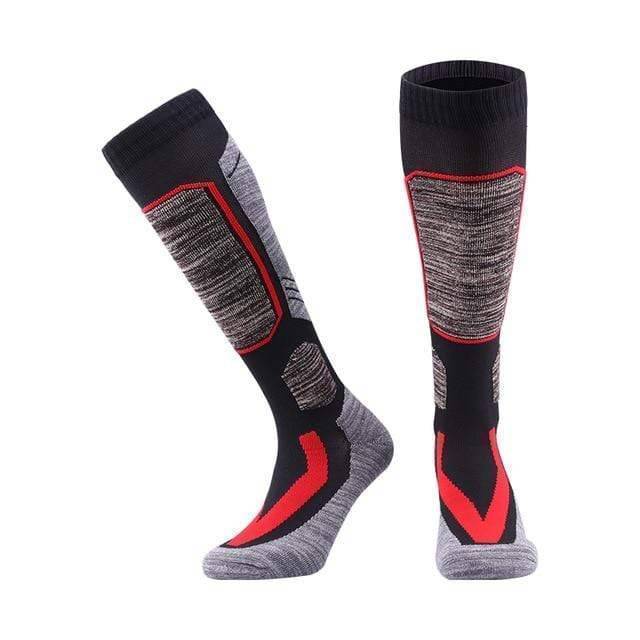 Model wearing black unisex thermal fleece winter socks, paired with ski boots, illustrating their use for cold weather sports.