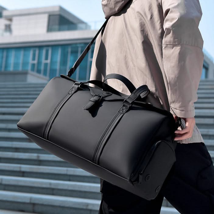 Versatile black unisex duffle bag with shoe compartment, ideal for weekend travel & gym.