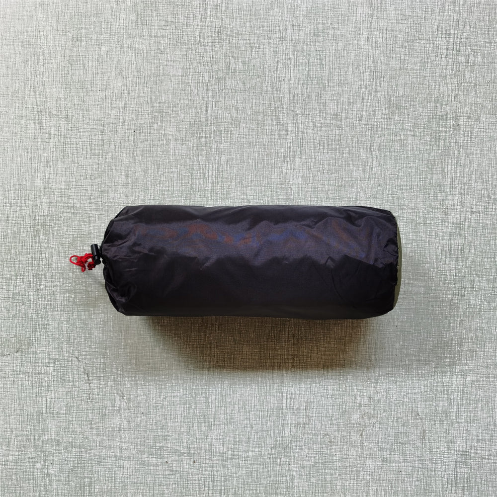 Image of a rolled-up ultralight tent, showing how small and portable it is for any outdoor adventure.