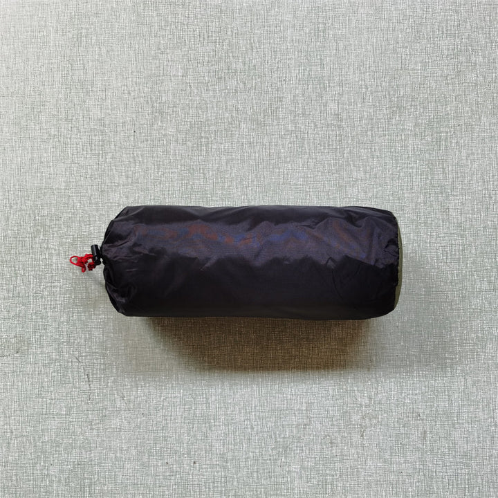 Image of a rolled-up ultralight tent, showing how small and portable it is for any outdoor adventure.