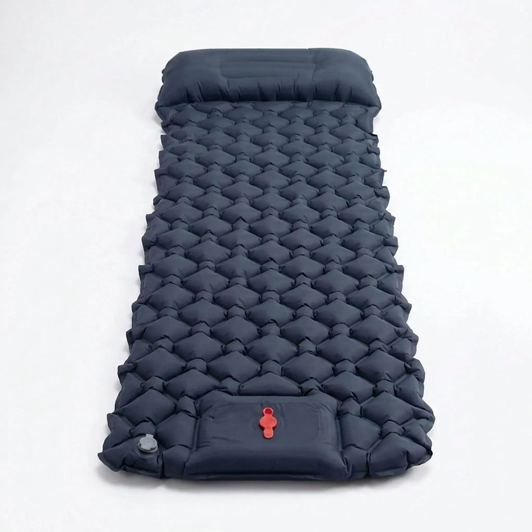 Outdoor enthusiast inflates an ultralight camping sleeping pad using its convenient built-in foot pump.