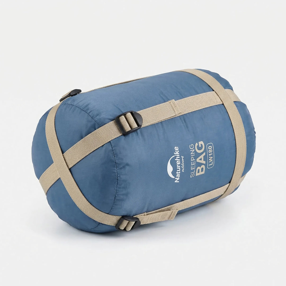 Unisex ultralight summer sleeping bag laid out at a scenic campsite, perfect for hiking & outdoor adventures.