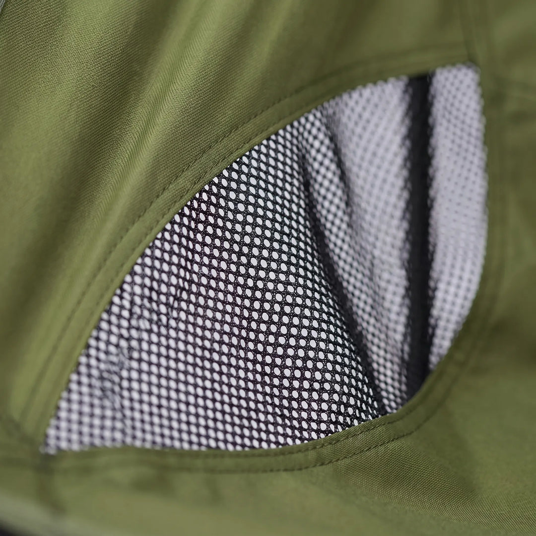 Person relaxing in a portable mesh camping chair by a campfire, ideal ultralight outdoor furniture.
