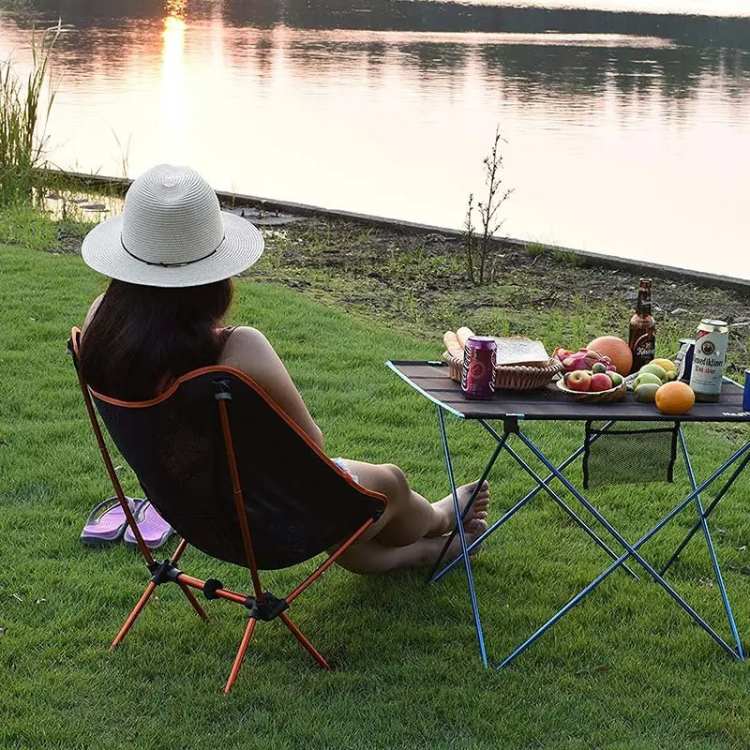 Compact portable folding camp chair shown with carry bag, highlighting its ultralight design for travel and recreation.