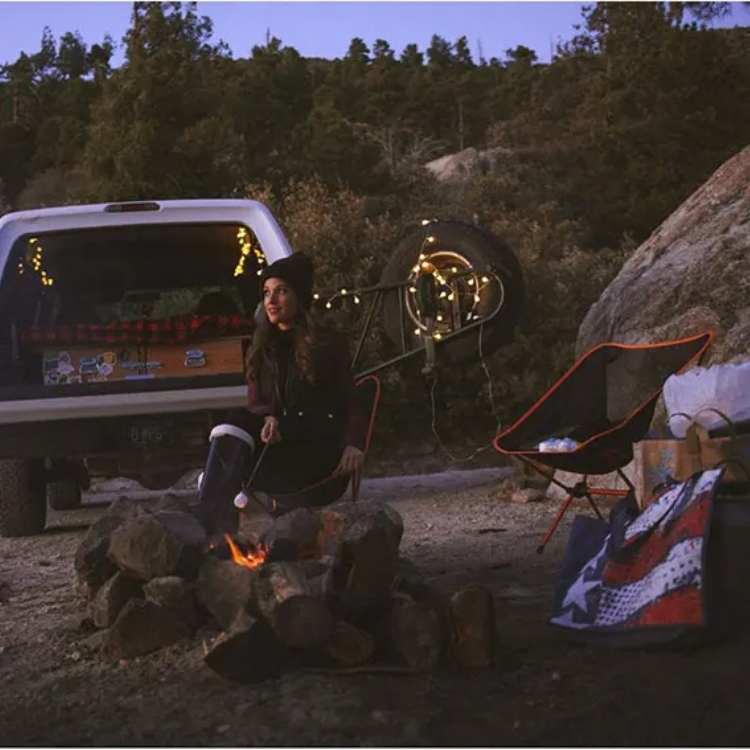 Side view of a blue ultralight portable folding camp chair, demonstrating its sturdy frame for outdoor gear.