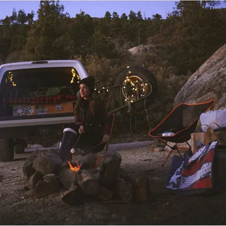 Side view of a blue ultralight portable folding camp chair, demonstrating its sturdy frame for outdoor gear.
