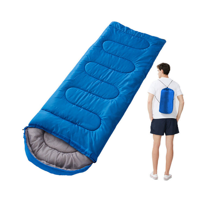 Lightweight travel sleeping bag next to camp tent, essential gear for hiking trips