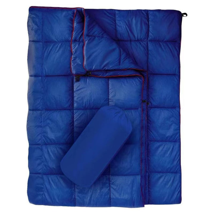 Compact ultralight camping blanket next to a backpack, travel essential.