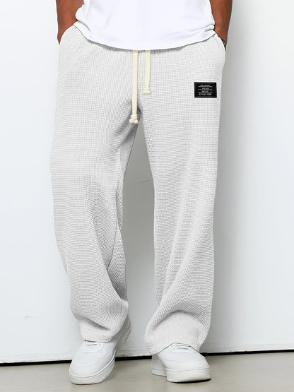 Soft waffle knit relaxed lounge pants for unisex comfort. Casual, wide-leg design with an adjustable drawstring.