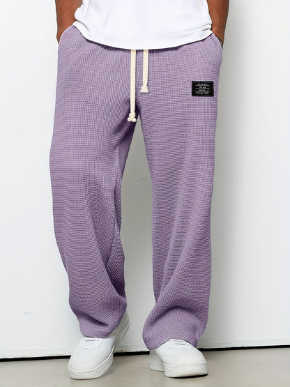 Waffle knit unisex lounge pants, relaxed fit with a drawstring. Soft, wide-leg comfort wear for casual style.