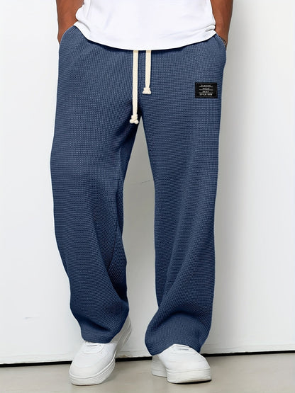 Soft waffle knit relaxed fit lounge pants. Unisex design, wide leg, and drawstring for casual comfort wear.