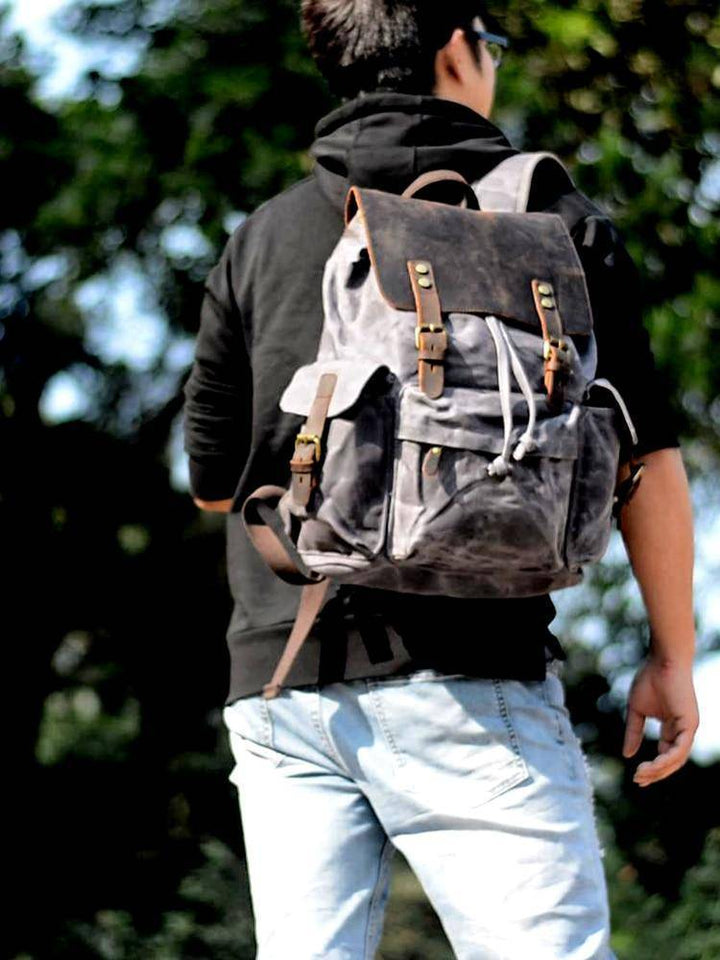 Unisex durable waterproof canvas backpack with leather accents, perfect for outdoor adventures