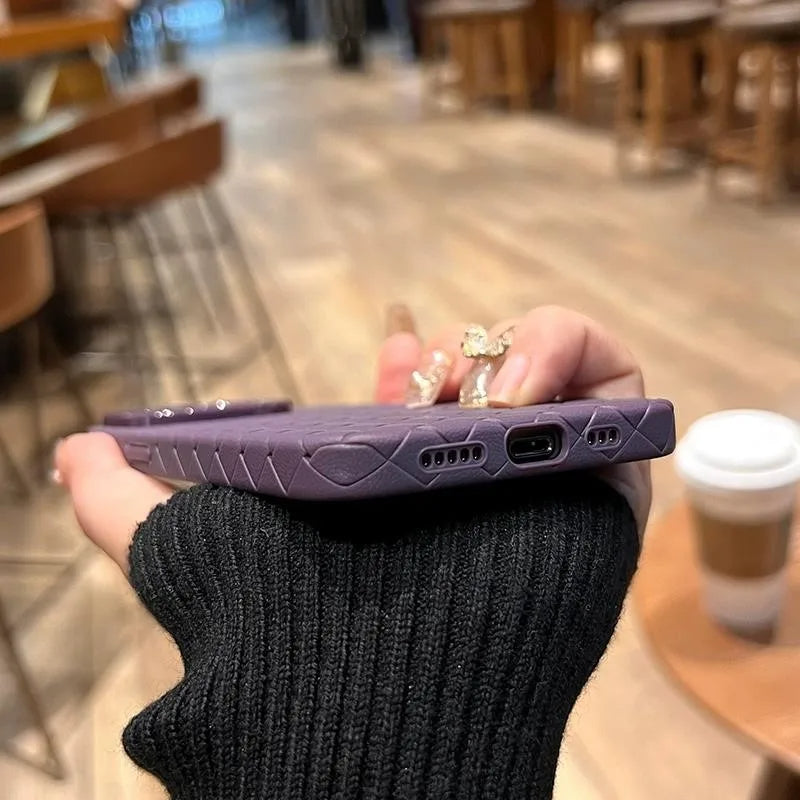 Hand holding a unisex woven texture iPhone case, showcasing slim design & protective shockproof features.