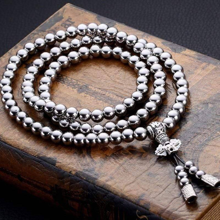 Tactical Buddha Beads EDC Chain, coiled neatly on a rustic wooden surface, ready for adventure.
