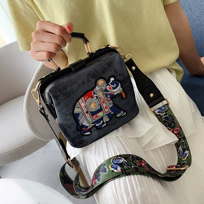 Close-up of detailed mandala embroidery on a bohemian shoulder bag accessory.