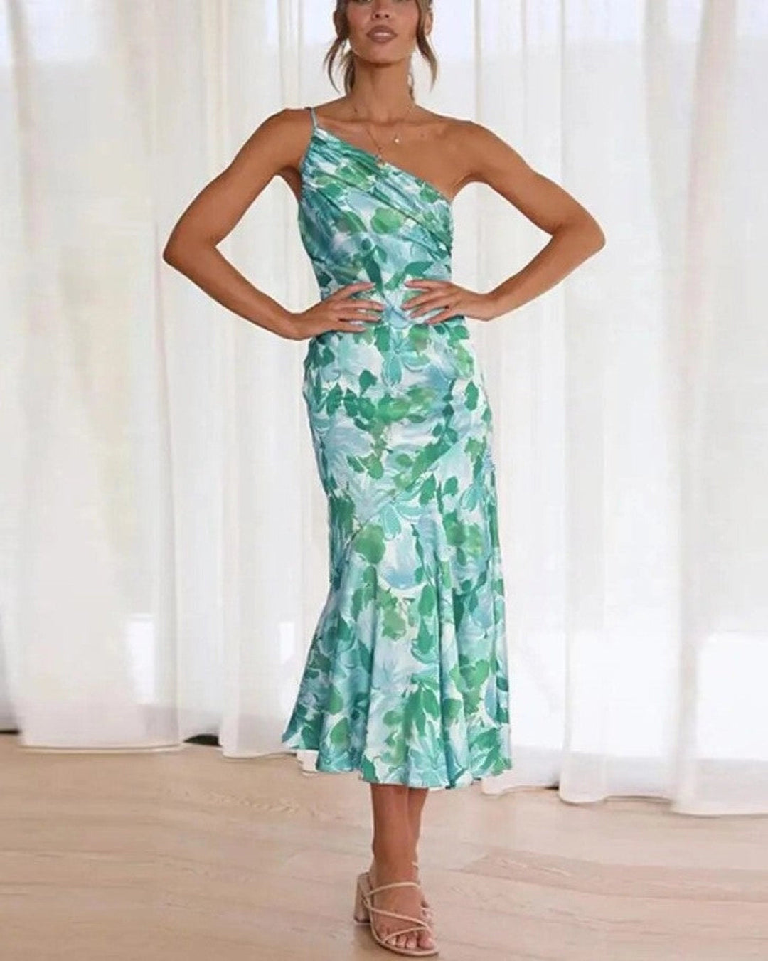 Trendy women's sleeveless floral midi dress with a unique asymmetric flowing hem for vibrant summer fashion.