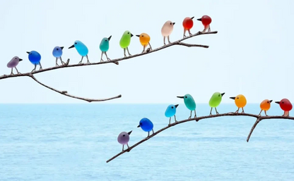 Sustainable sea glass bird art, featuring a delicate rainbow design on driftwood, ideal for nature-lovers.