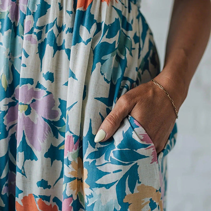 Stylish women's floral maxi dress. Smocked for comfort, sleeveless summer fashion with a vibrant print & ruffled hem.