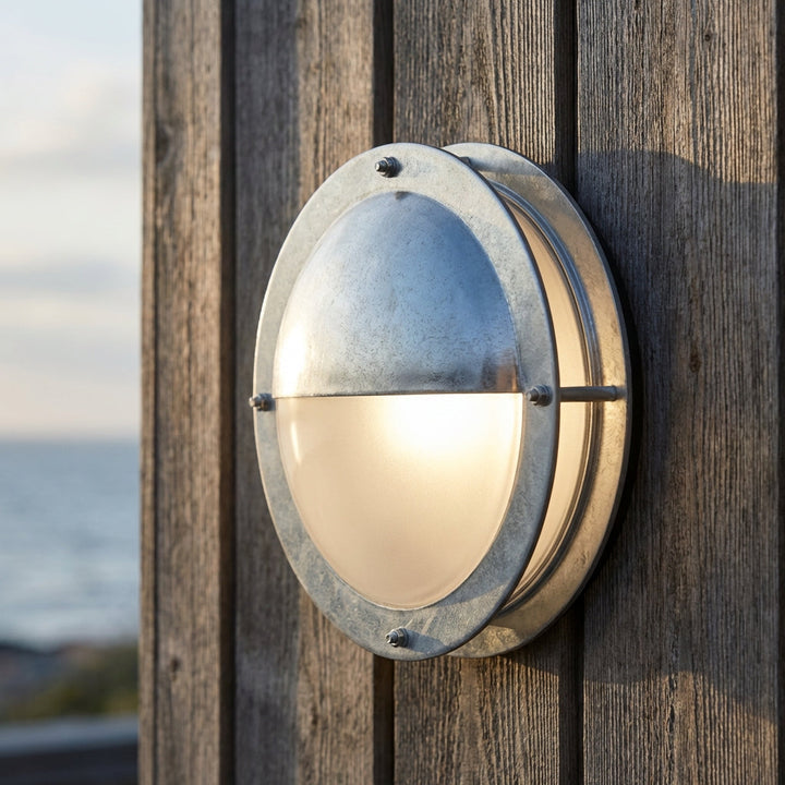 Weatherproof galvanized steel round outdoor wall light. Durable exterior lighting for porch, patio, or garden.