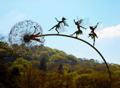 Decorative metal art stake featuring a dancing fairy with a dandelion, ideal for garden or patio.