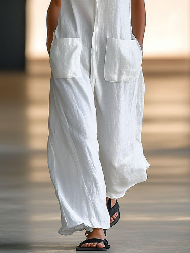 Casual white women's sleeveless jumpsuit with button front, pockets, and wide legs. Effortless retro style.