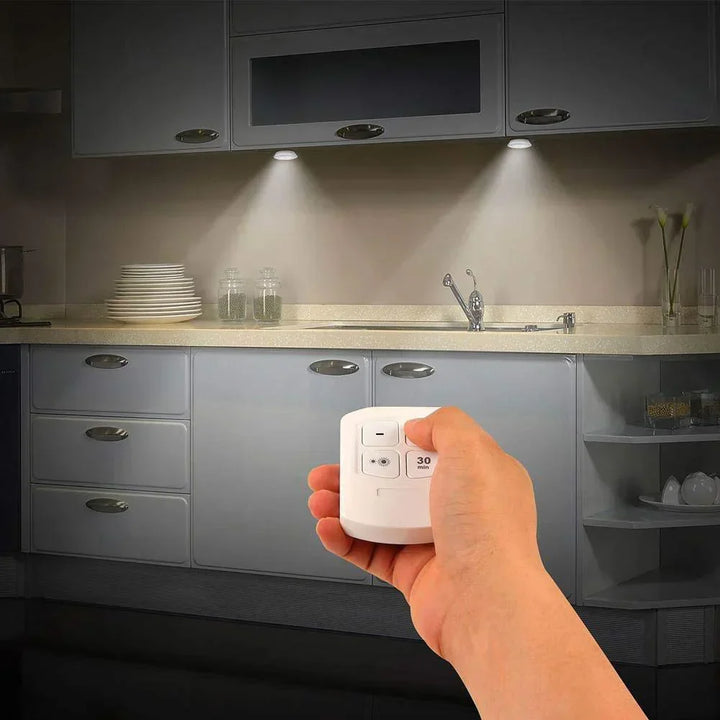 Set of wireless LED puck lights installed in a row, providing uniform under cabinet illumination.