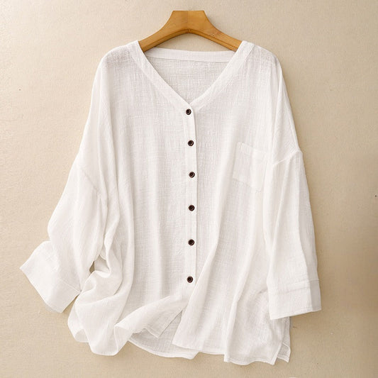 Woman wearing an elegant white draped button-up shirt with long sleeves, perfect for relaxed casual spring and summer style.
