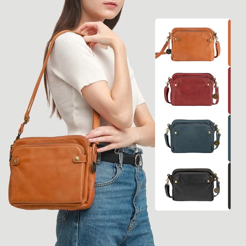 Close-up: secure zippers & quality leather on a women's 3-layer crossbody clutch.