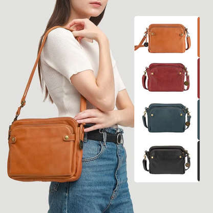 Close-up: secure zippers & quality leather on a women's 3-layer crossbody clutch.