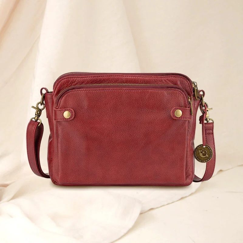 Interior view: multiple compartments in a women's organized 3-layer leather crossbody bag.
