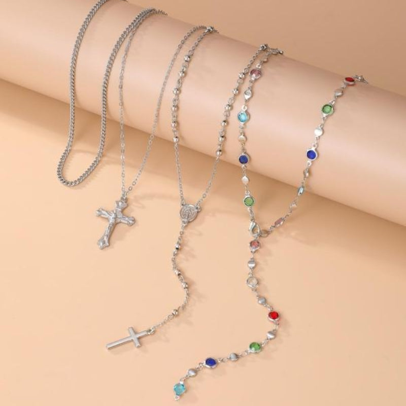 Women's 4-piece layered cross necklace. Elegant gold & silver pendant set with crystal accents for spiritual style.