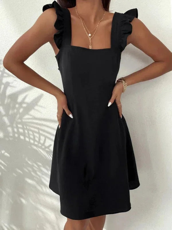 Women's flirty party mini dress, A-line silhouette, adorned with ruffle straps and a bow back.