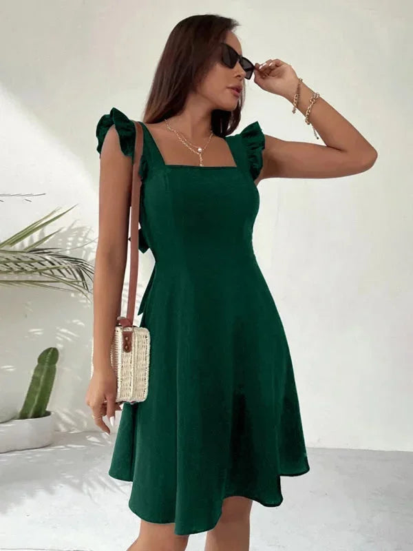 Adorable women's mini dress: A-line shape, soft ruffle straps, and a sweet bow detail on the back.