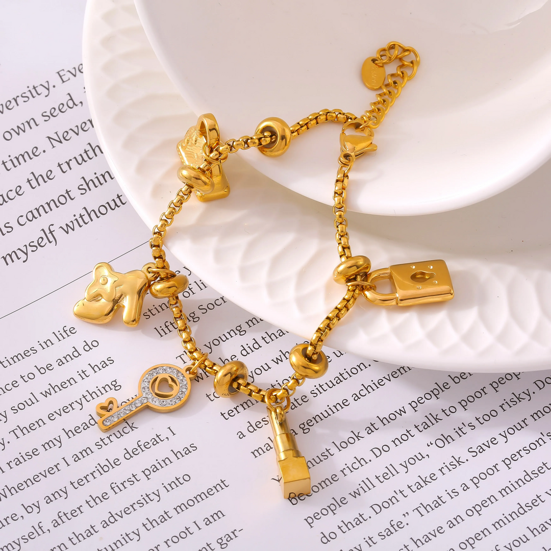 Gold-tone adjustable charm bracelet for women, featuring unique rhinestone-studded charms. Elegant jewelry.