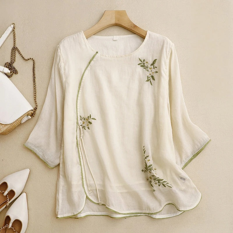 Peach women's wrap blouse with delicate embroidery, a stylish short sleeve top for elegant casual wear.