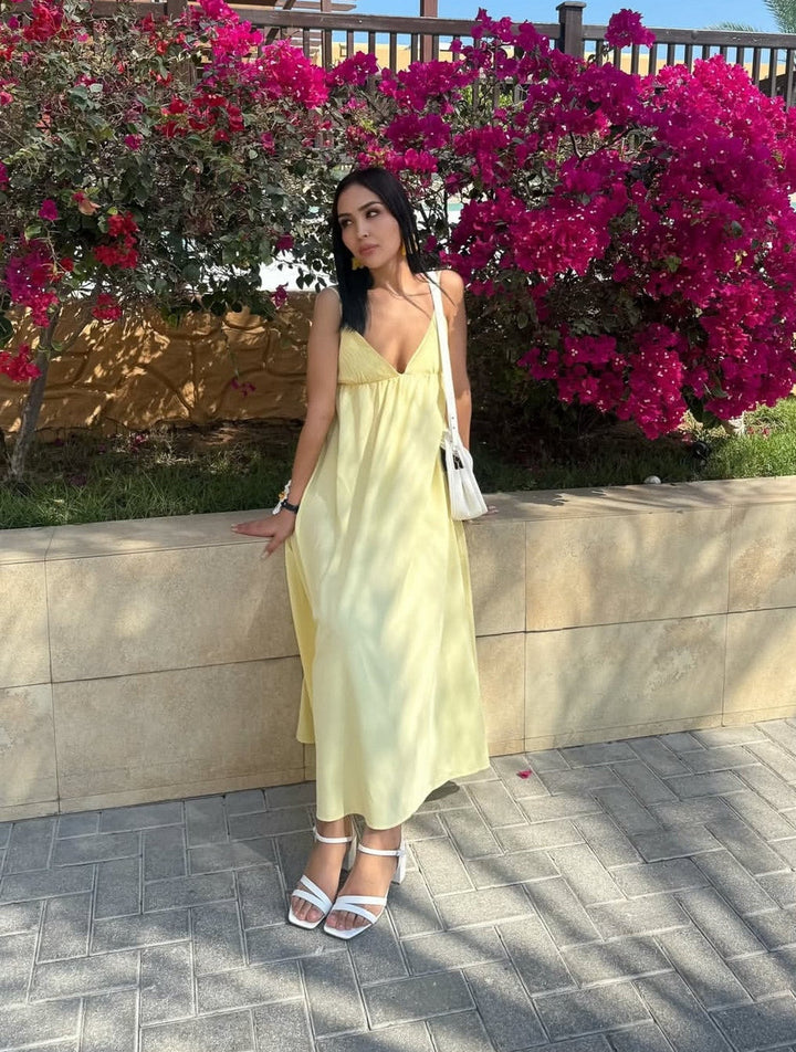 Elegant white backless spaghetti strap maxi dress with a V-neck, ideal for summer beachwear or vacation.