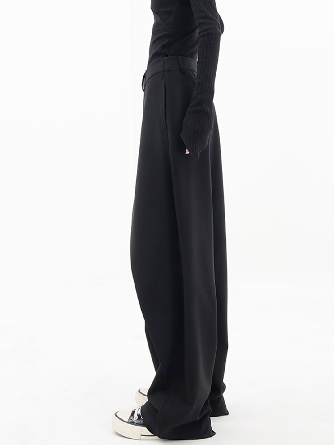Textured detail of chic women's baggy trousers; modern design with relaxed fit and unique asymmetric waist.